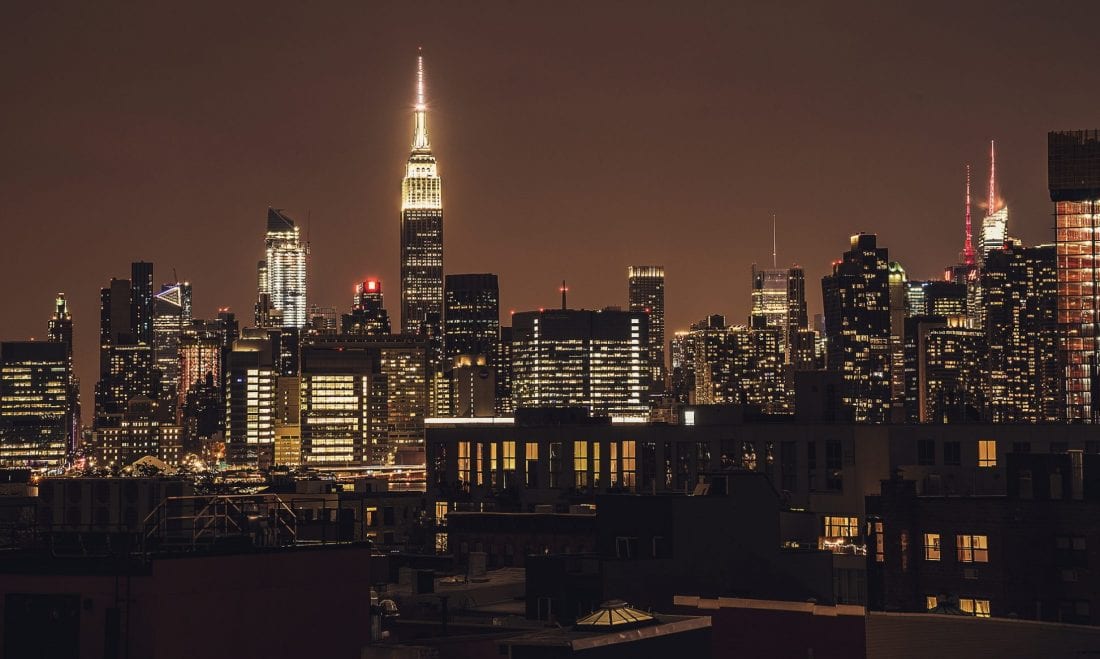 The Manhattan skyline at night as seen from a rooftop in Greenpoint Brooklyn