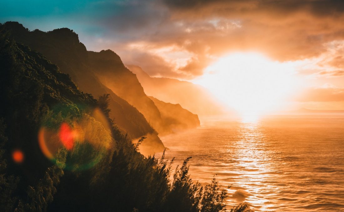 sunset over cliffs by the shore in hawaii, things to do in hawaii