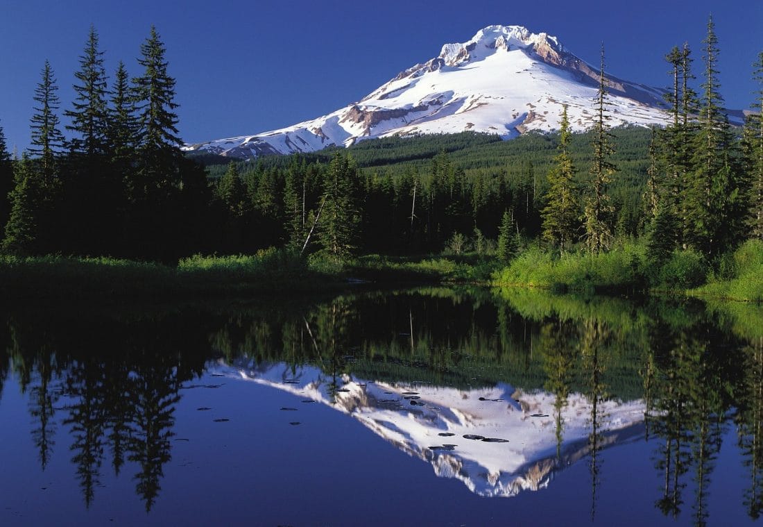 Mount Hood reflecting off of a blue lake in Oregon
