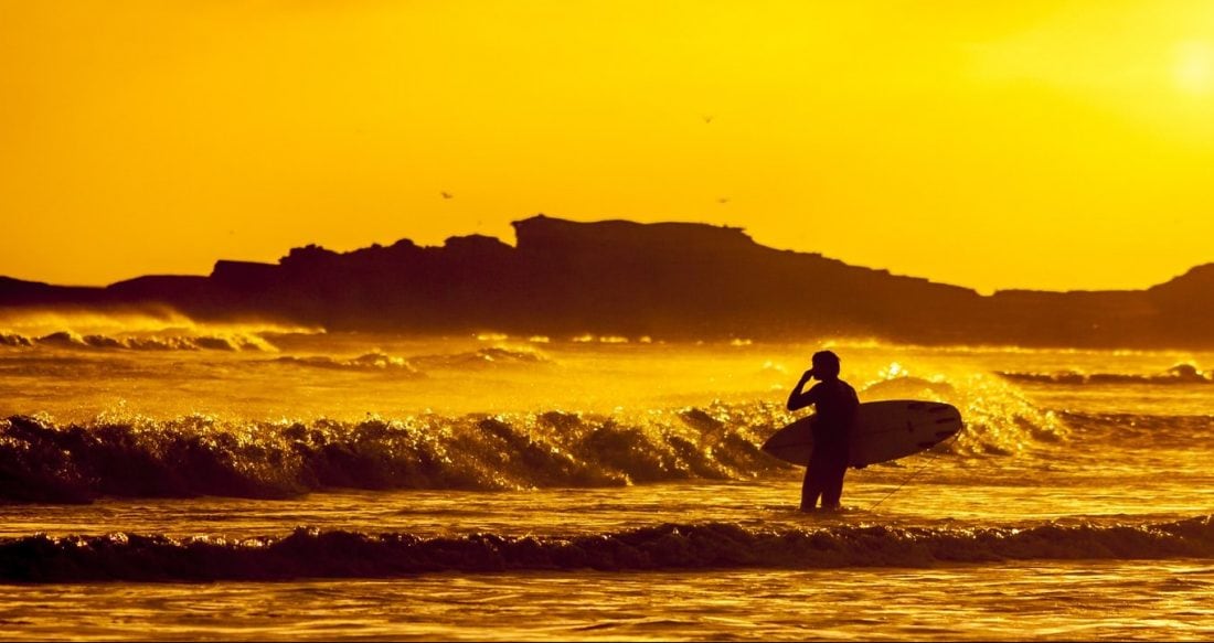 a surfer jusging the waves during sunset in Ensenada