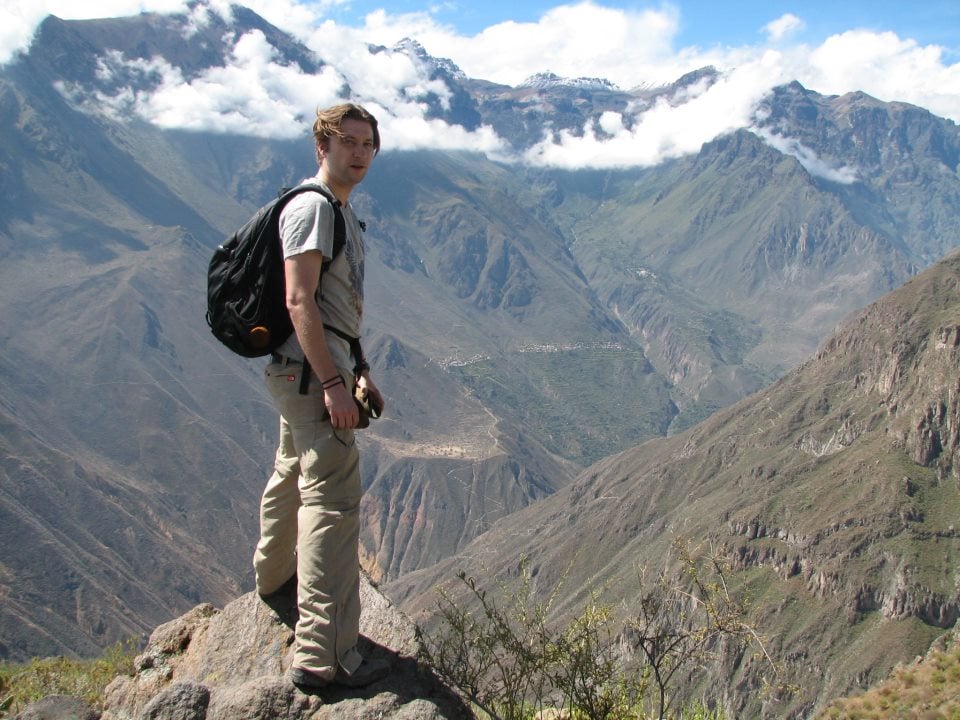 Man standing on a rock overlooking a beautiful valley in Peru